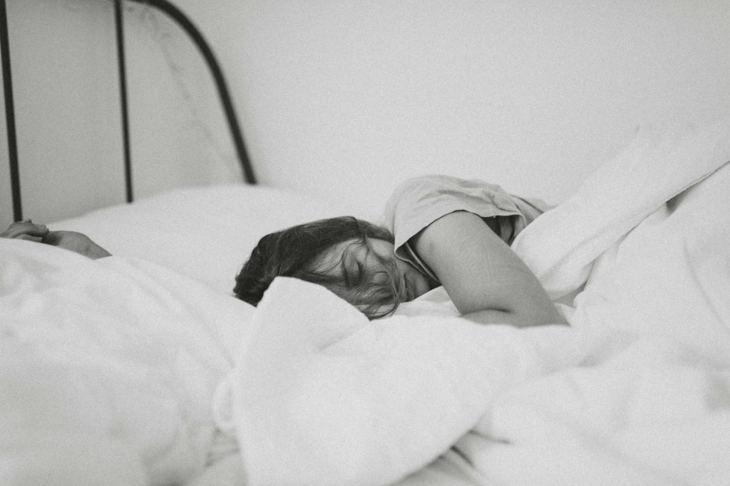 Black and white photo of woman sleeping in bed